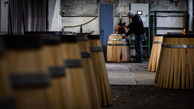 Tonnelier contrôlant la chauffe d’un fût en chêne à la Tonnellerie Remond.