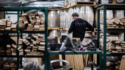 Tonnelier travaillant sur des fûts en chêne dans l’atelier de la Tonnellerie Remond.