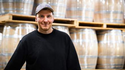 Thierry Grivot, master cooper at Tonnellerie Remond, standing in front of oak barrels