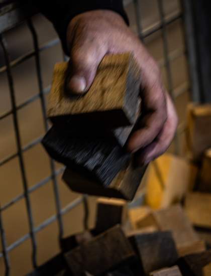 Main de tonnelier tenant des morceaux de chêne à la Tonnellerie Remond.