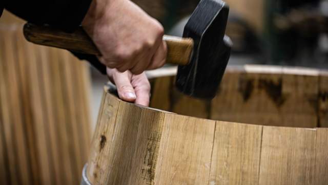 Tonnelier ajustant les douelles d’un fût en chêne à la Tonnellerie Remond.